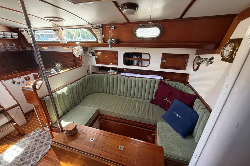 Slide: The Image of Cozy interior of 1984 Hinckley Sou'wester 42 sailboat with green upholstered seating. - 45