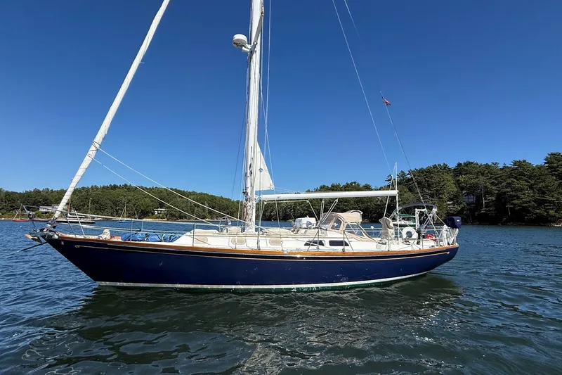 The Image of 1984 Hinckley Sou'wester 42 sailboat on calm water, clear blue sky background. - 0