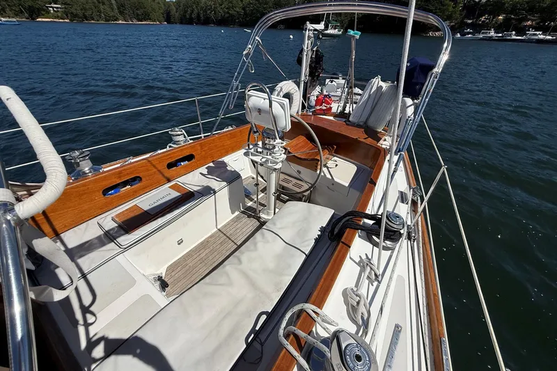 Slide: The Image of Cockpit of 1984 Hinckley Sou'wester 42 sailboat on calm water, showcasing elegant woodwork. - 10