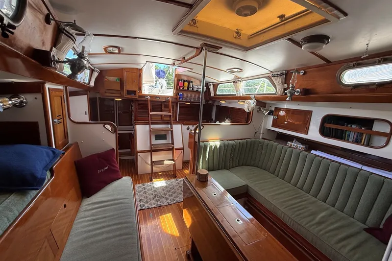 Slide: The Image of Interior of 1984 Hinckley Sou'wester 42 sailboat with wood finish and green seating. - 46