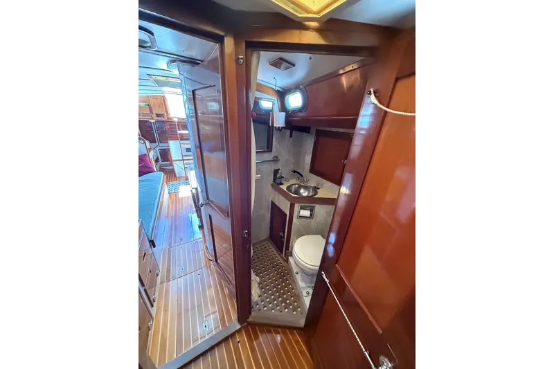 Slide: The Image of Interior of 1984 Hinckley Sou'wester 42 yacht, featuring a compact bathroom with wooden finishes. - 55