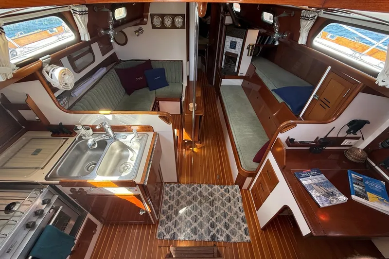 Slide: The Image of 1984 Hinckley Sou'wester 42 yacht interior with wood finish, kitchen, and seating area. - 34