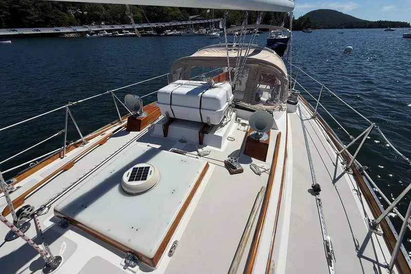 Slide: The Image of 1984 Hinckley Sou'wester 42 sailboat deck with scenic water and mountain backdrop. - 17