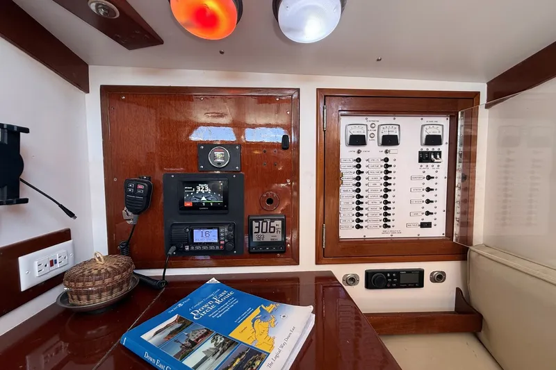 Slide: The Image of Hinckley Sou'wester 42 yacht control panel with navigation equipment and a nautical chart book. - 42