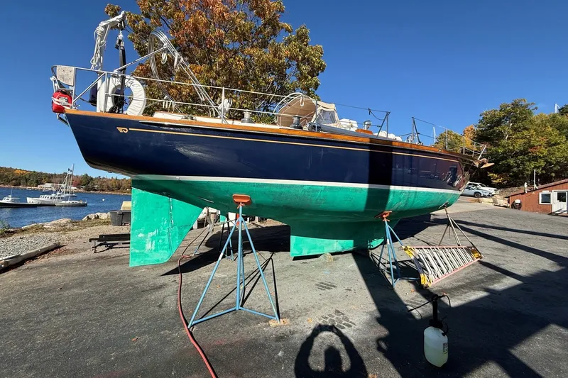Slide: The Image of 1984 Hinckley Sou'wester 42 sailboat on stands, vibrant blue hull, dockside setting. - 60