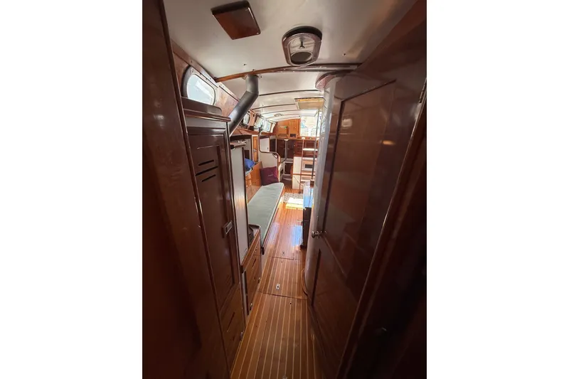 Slide: The Image of Interior view of 1984 Hinckley Sou'wester 42 sailboat, featuring wooden cabinetry and flooring. - 53