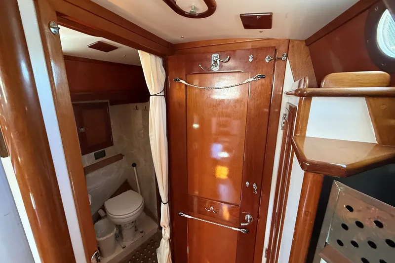 Slide: The Image of Interior of 1984 Hinckley Sou'wester 42 sailboat, featuring wooden cabinetry and compact bathroom. - 51