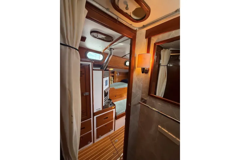 Slide: The Image of Interior of 1984 Hinckley Sou'wester 42 sailboat, featuring wood paneling and cozy cabin space. - 52