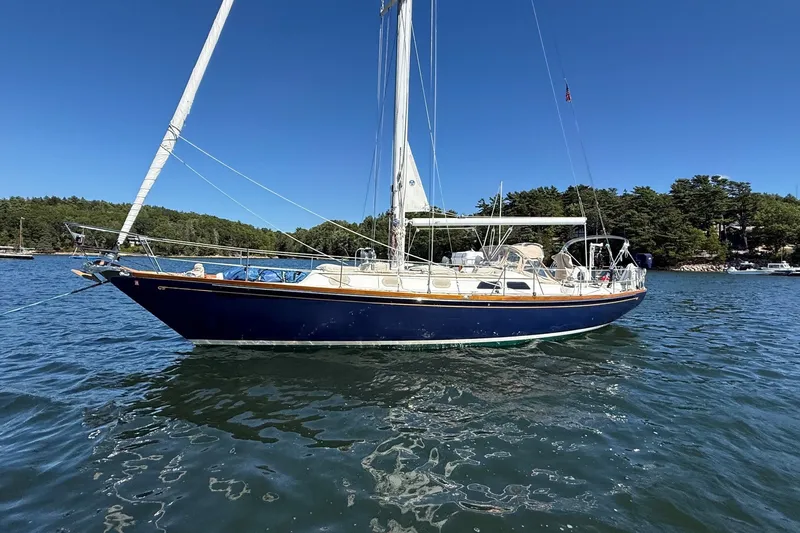 Slide: The Image of 1984 Hinckley Sou'wester 42 sailboat on calm water, surrounded by trees. - 6