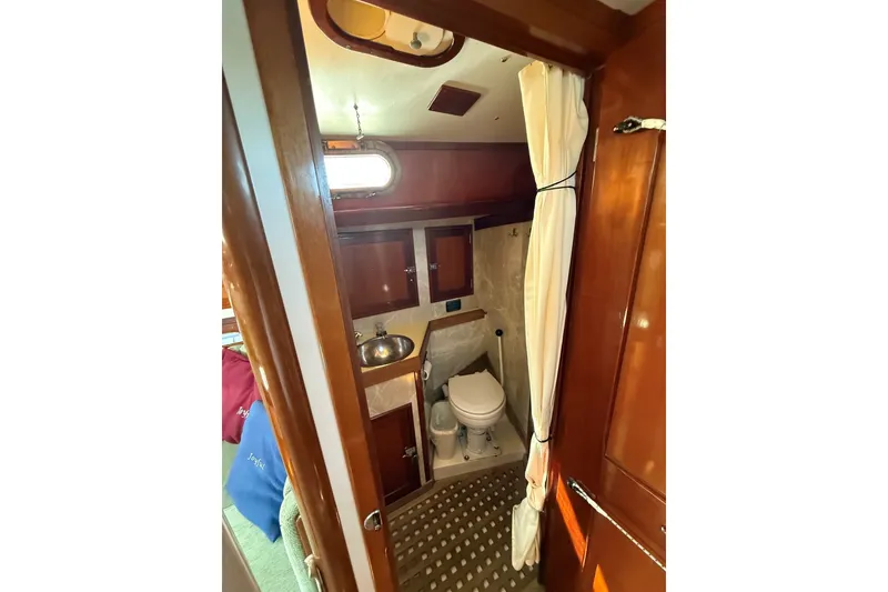 Slide: The Image of 1984 Hinckley Sou'wester 42 yacht bathroom with wooden cabinetry and compact design. - 56