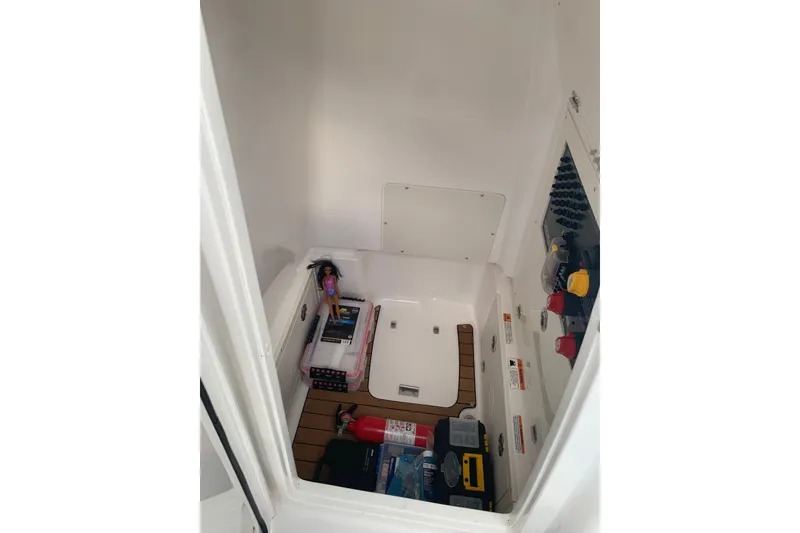 Slide: The Image of Storage compartment of 2020 Caymas 26 HB boat with safety equipment and accessories. - 13