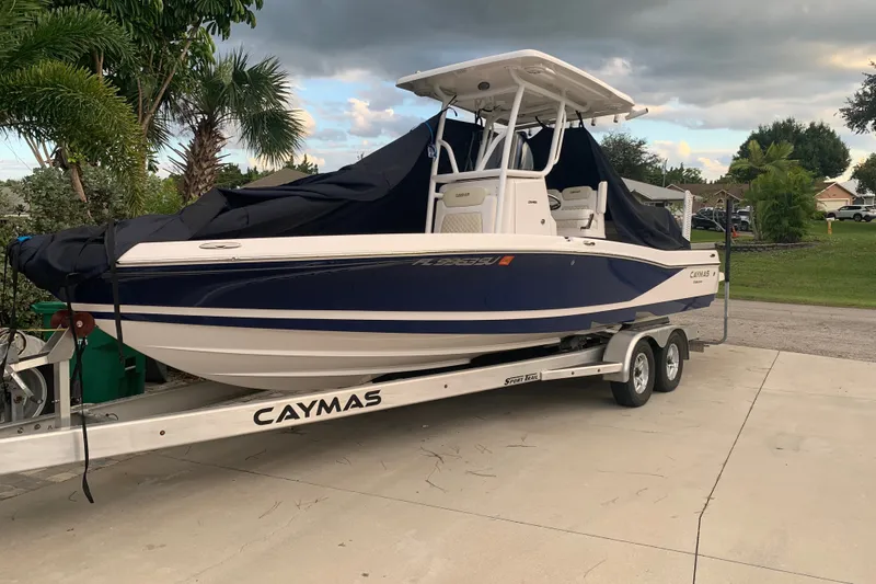 The Image of 2020 Caymas 26 HB boat on trailer, covered, parked on driveway with palm trees nearby. - 0