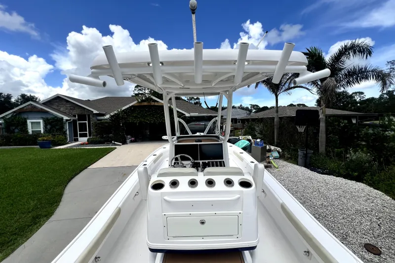 Slide: The Image of 2020 Caymas 26 HB boat with T-top, parked in a residential driveway. - 27