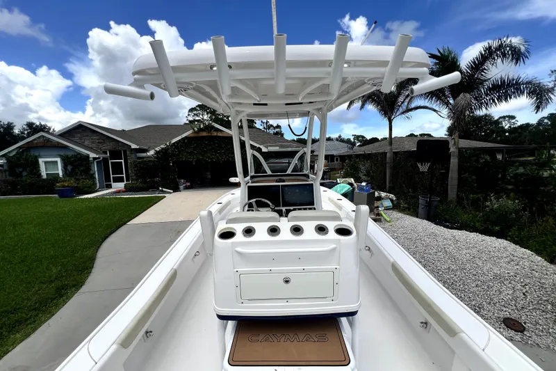 Slide: The Image of 2020 Caymas 26 HB boat with center console, docked in a residential driveway. - 31