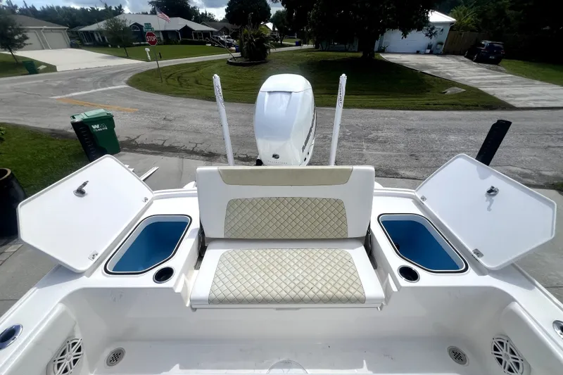 Slide: The Image of 2020 Caymas 26 HB boat with open storage compartments and cushioned seating. - 86