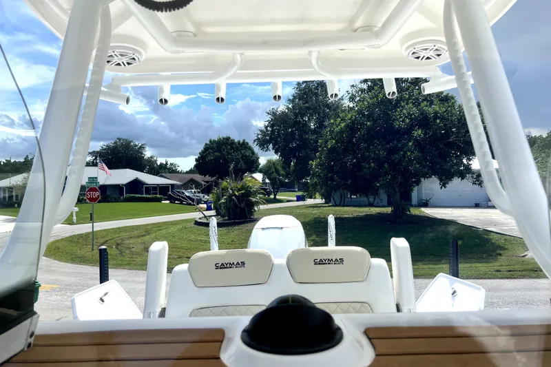 Slide: The Image of 2020 Caymas 26 HB boat interior with seating, viewed from helm, residential street background. - 64