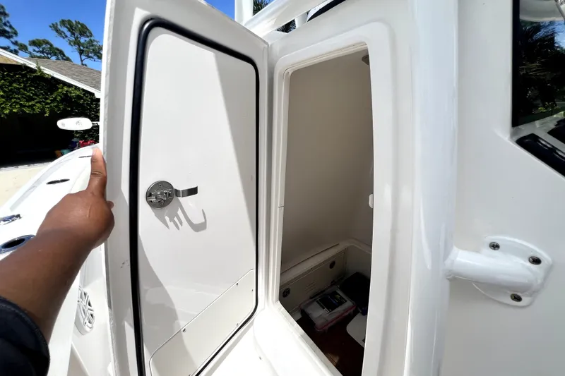 Slide: The Image of 2020 Caymas 26 HB boat storage compartment with open door, showcasing interior space. - 63