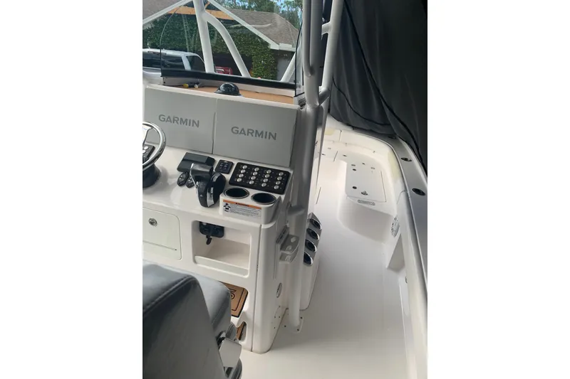 Slide: The Image of 2020 Caymas 26 HB boat cockpit with Garmin navigation displays and control panel. - 2