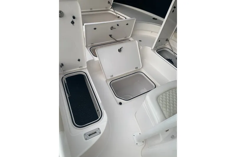 Slide: The Image of 2020 Caymas 26 HB boat interior with open storage compartments and seating. - 10