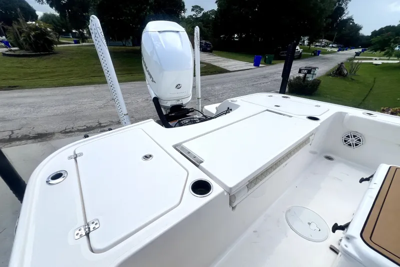 Slide: The Image of 2020 Caymas 26 HB boat with Mercury outboard motor, parked on a residential street. - 85