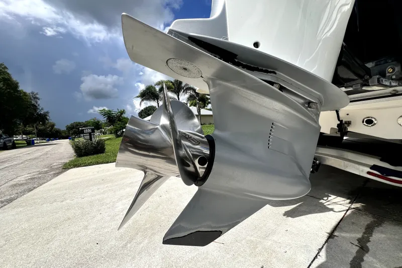 Slide: The Image of 2020 Caymas 26 HB boat propeller, shiny metal finish, parked on a residential street. - 14