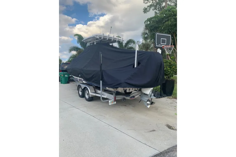 Slide: The Image of Covered 2020 Caymas 26 HB boat on trailer in driveway with basketball hoop nearby. - 7