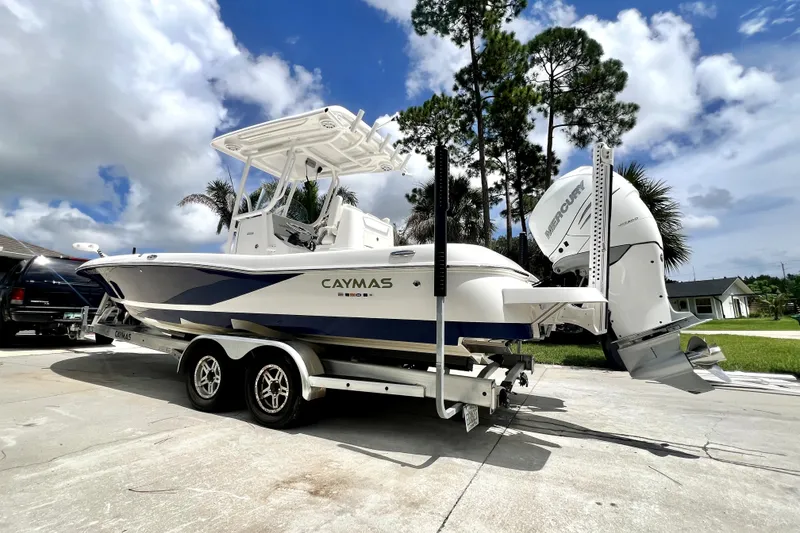 Slide: The Image of 2020 Caymas 26 HB boat on trailer, parked outdoors under a cloudy sky. - 2