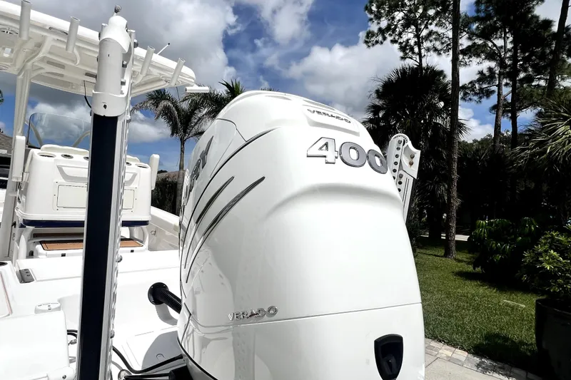 Slide: The Image of 2020 Caymas 26 HB boat with powerful 400 Verado engine, surrounded by lush greenery. - 18