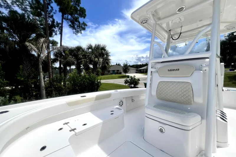 Slide: The Image of 2020 Caymas 26 HB boat interior with seating, surrounded by palm trees and blue sky. - 52