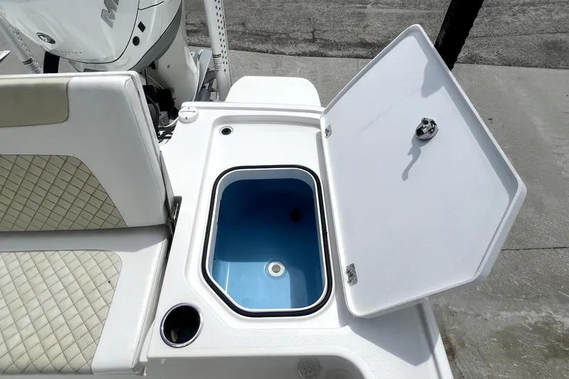 Slide: The Image of Open storage compartment on 2020 Caymas 26 HB boat, featuring a blue interior. - 89