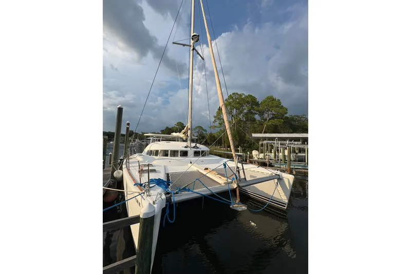 The Image of 2001 Lagoon 410 catamaran docked at marina under cloudy sky. - 1