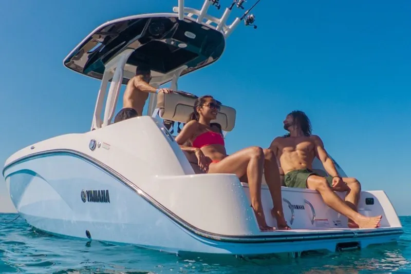 Slide: The Image of People relaxing on a 2027 Yamaha Boats 222 FSH Sport E in clear blue waters. - 4