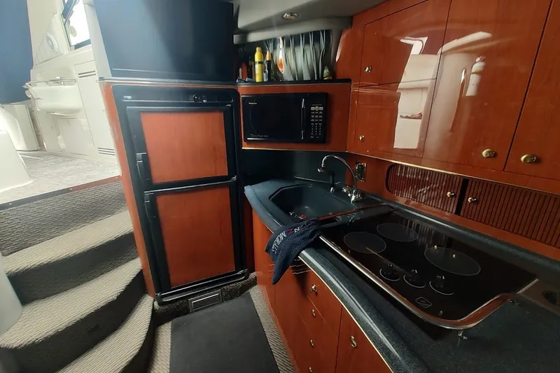 Slide: The Image of Interior of 1998 Sea Ray Sundancer 400 yacht kitchen with wood cabinetry and modern appliances. - 11