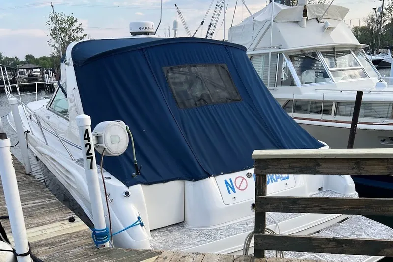 Slide: The Image of 1998 Sea Ray Sundancer 400 docked, featuring a blue cover and marina surroundings. - 4