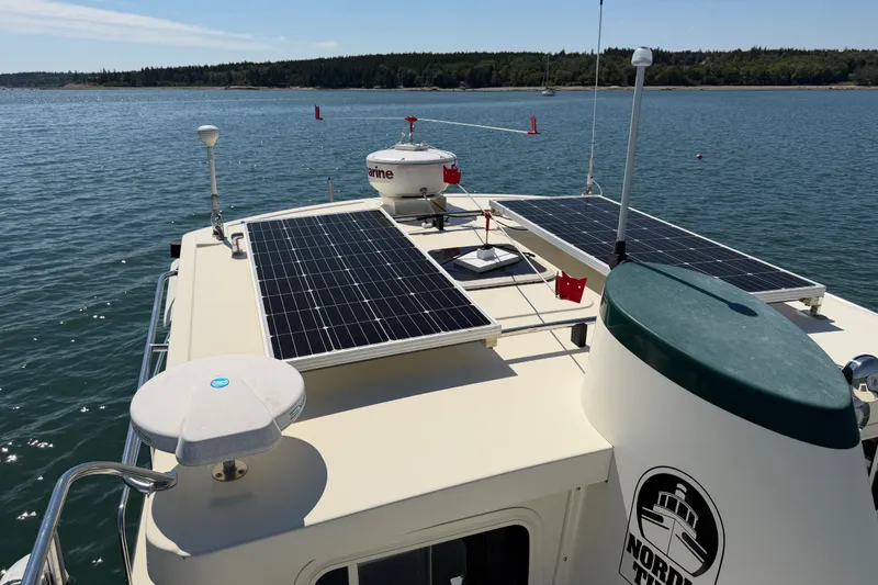 Slide: The Image of Nordic Tug 32 (2001) with solar panels on deck, cruising in calm waters. - 12
