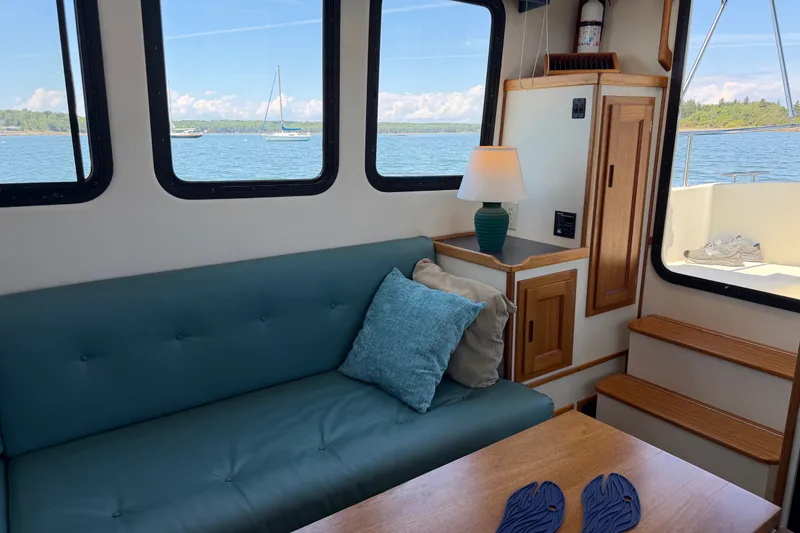 Slide: The Image of Interior of a 2001 Nordic Tug 32 with a cozy seating area and scenic water view. - 28