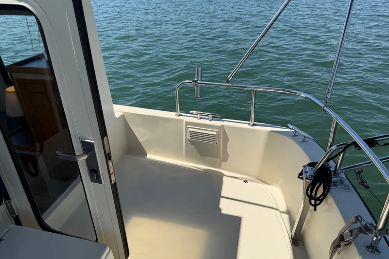 Slide: The Image of 2001 Nordic Tug 32 boat deck with railing, overlooking calm water. - 7