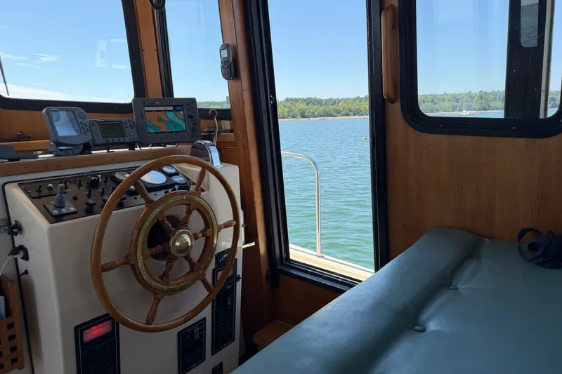 Slide: The Image of Interior view of a 2001 Nordic Tug 32 boat with steering wheel and navigation equipment. - 36