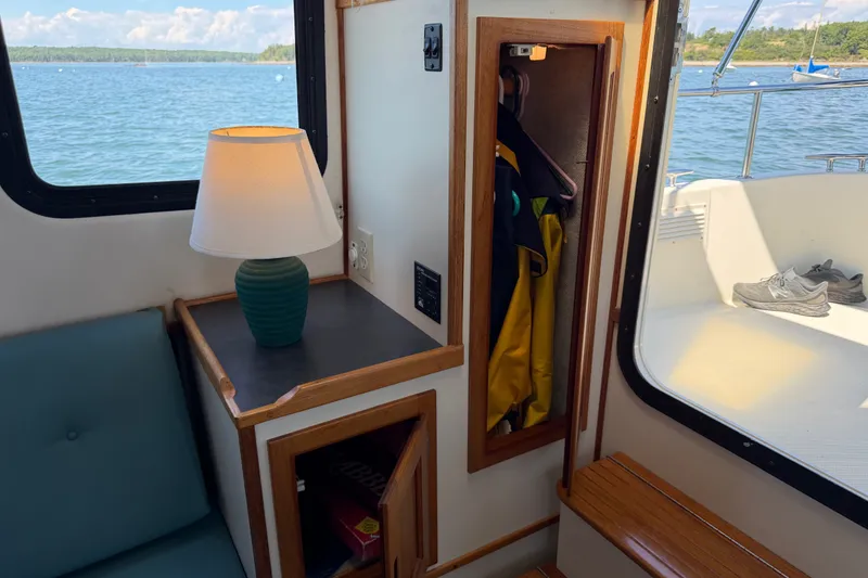 Slide: The Image of Interior of a 2001 Nordic Tug 32 with lamp, closet, and scenic water view. - 32