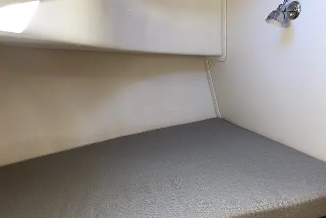 Slide: The Image of Interior cabin of a 2001 Nordic Tug 32, featuring a simple bed and reading light. - 69