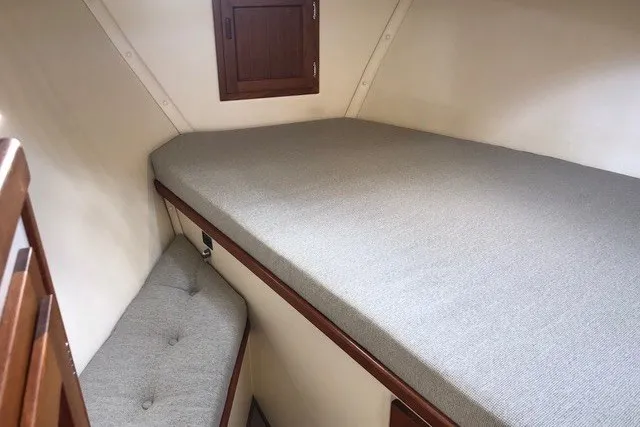 Slide: The Image of Cozy cabin interior of 2001 Nordic Tug 32 with cushioned bed and wooden accents. - 67