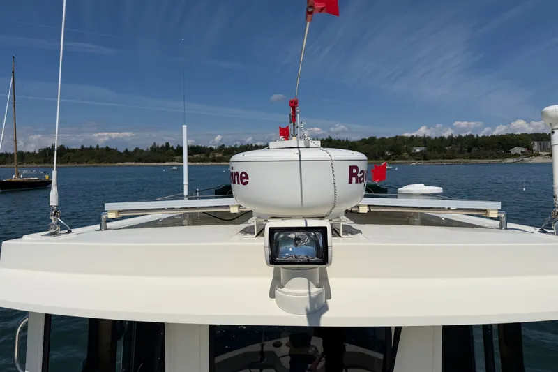 Slide: The Image of Nordic Tug 32 boat, 2001 model, with radar equipment on calm waters under a clear sky. - 19