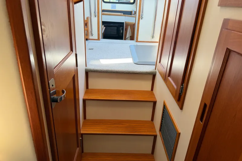 Slide: The Image of Interior view of 2001 Nordic Tug 32, featuring wooden stairs and cabinetry. - 56