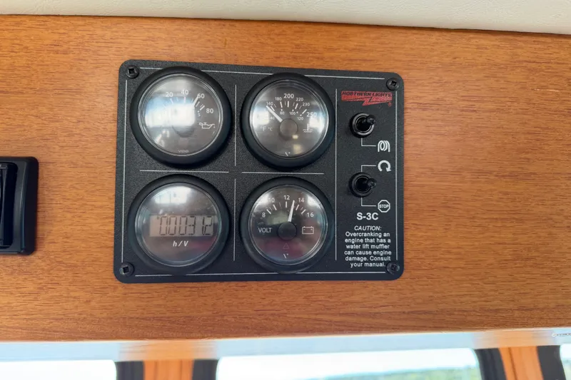 Slide: The Image of Control panel of a 2001 Nordic Tug 32 boat with gauges and caution label. - 43