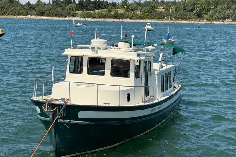 Slide: The Image of 2001 Nordic Tug 32 boat anchored in scenic coastal waters. - 5