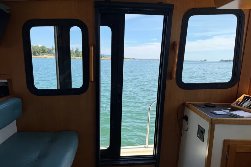 Slide: The Image of Interior view from a 2001 Nordic Tug 32, overlooking serene waters through cabin windows. - 25