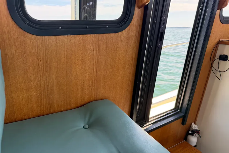 Slide: The Image of Interior of a 2001 Nordic Tug 32 with wooden paneling and ocean view through window. - 27