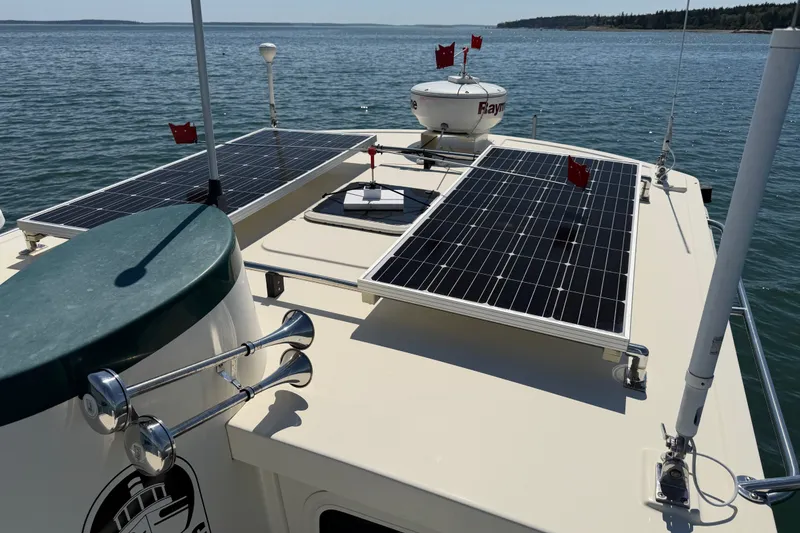 Slide: The Image of Nordic Tug 32 (2001) with solar panels on the roof, cruising on a calm sea. - 13