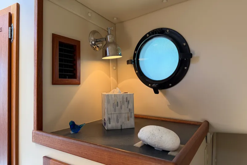 Slide: The Image of Cozy interior of 2001 Nordic Tug 32 with porthole and decorative items. - 70