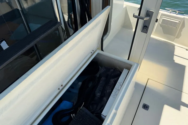 Slide: The Image of Storage compartment on a 2001 Nordic Tug 32 boat, open with various items inside. - 10